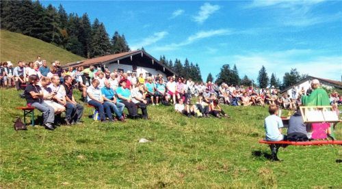 Gläubige feiern Bergmessen unter weiß-blauem Himmel