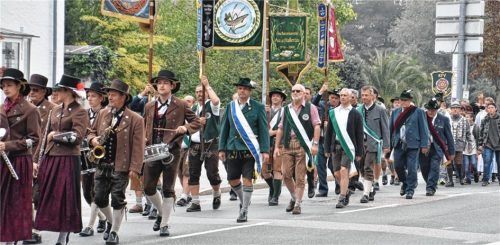 Großer Tag für die Fischer: Links der Festzug mit Fahnenabordnungen durch Rosenheim, rechts die Geehrten. Dr. Bernhard Gum von der Fischereifachberatung und Rainer Schäfer, Vorstand des Kreisfischereivereins Rosenheim, wurden für ihre Verdienste mit der Ehrennadel in Gold ausgezeichnet.
