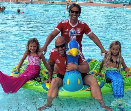 Trend auch im Kolbermoorer Freibad: Meerjungfrauen. Bis zu 20 Mädchen mit Meerjungfrauen-Flosse zählen die Bademeister Charly Meier (hinten) und Helmut Eggerl (vorne) schon mal an einem Nachmittag – und dabei entstand auch dieses Erinnerungsfoto.Foto re