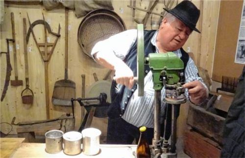 Der Brunner Bert in Aktion: Er hantierte mit einer Konservendosenverschlussmaschine, mit der man etwa um 1930 Lebensmittel in Konserven haltbar machte. „Damals ein Luxusgerät, das sich nur wenige leisten konnten“, so der Aschauer, der zum Organisationsteam der Ausstellung gehörte. Foto kme