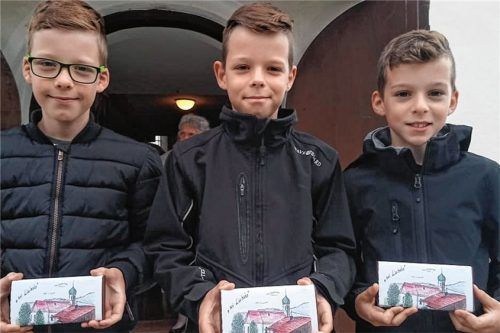 Die Drillinge Julian, Florian und Daniel (von links) freuten sich nach dem Gottesdienstbesuch über die Schokolade mit dem Bild der Pfraundorfer Kirche. Der Pfarrgemeinderat Pfraundorf dürfte sich über den Zuspruch und die „Inntalhilfe“ über den Erlös gefreut haben.Foto Ruprecht