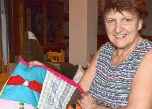 Katharina Schmid, die langjährige, ehemalige Vorsitzende des Weihnachtsmarktes Achenmühle e.V., präsentiert eine Neuheit: die „Demenzdecke“. Sie hält warm und von Demenz Betroffene können mit ihr nesteln, knöpfen oder knoten.Foto amf