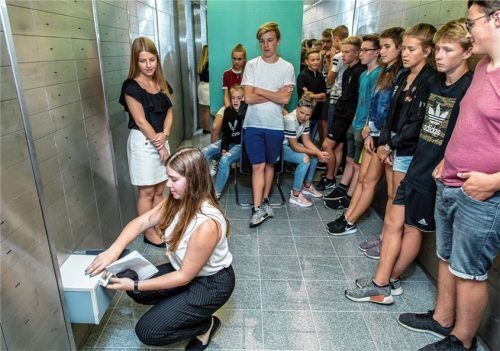 Was passiert im Tresorraum einer Bank? Die Azubis Nina Klausner (vorne kniend) und Sonja Schwager zeigen es den Schülern beim Besuch der Roadshow im Traunsteiner Hauptgebäude der Kreissparkasse Traunstein-Trostberg.Foto  eff