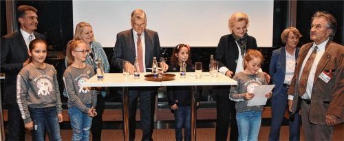 Am runden Tisch: (von links) Sozialdezernent Michael Keneder, Schulrätin Helga Wichmann, Vorstandsvorsitzender Sparkasse Rosenheim-Bad Aibling, Alfons Maierthaler, Oberbürgermeisterin Gabriele Bauer, Leiterin des Amtes für Kinder, Jugendliche und Familien, Caroline Rapp, und Vorsitzender des „FitZ“-Fördervereins, Wolfgang Zellner, sprechen mit den Kindern über die Besonderheiten von „FitZ“. Foto Schlecker