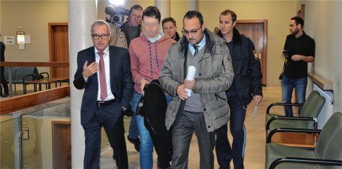 Die Anklage lautet auf Mord aus Heimtücke: Der Hauptangeklagte (roter Pulli) mit seinen Verteidigern Dr. Herbert Buchner (links) und Dr. Adam Ahmed sowie Polizeibeamten auf dem Weg zum Gerichtssaal. Foto kd