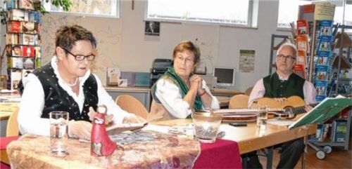 Erzählte launig über den Deko-Wahnsinn, das Lichterketten-Wettrüsten und eigene Krampus-Erlebnisse: Lisa Stögbauer (links). Den musikalischen Rahmen gestalteten Gertrud Gaigl an der Zither und Ralf Vogel mit der Gitarre. Foto bac