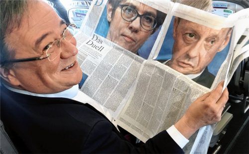 Machtkampf in der CDU: Armin Laschet (CDU), Ministerpräsident von Nordrhein-Westfalen, liest in einer Zeitung über das Duell zwischen Annegret Kramp-Karrenbauer und Friedrich Merz. Foto dpa