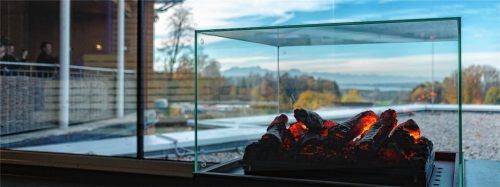 Schöner geht’s kaum: Der Blick aus der neuen Panorama-Sauna über den Simssee in die Berge ist traumhaft. Vorne glühen die Scheite. Foto thomae