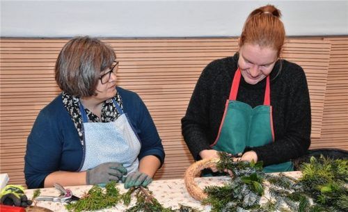 Bei der Arbeit: Fachlehrerin Gertrud Aicher (links) erklärt OVB-Volontärin Anna Heise wie das Binden eines Adventskranzes funktioniert. Fotos Schlecker
