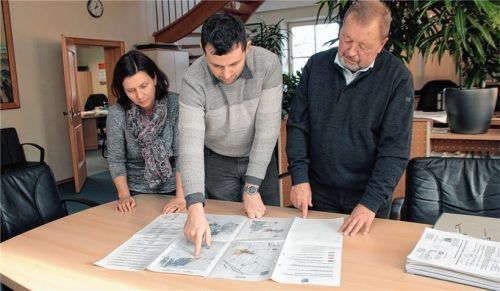 Besprechung im Amtszimmer in Babensham: Verwaltungsangestellte Evi Hartl und Geschäftsleiter Martin Kubiczek erläutern mit ihm einen Bebauungsplan.