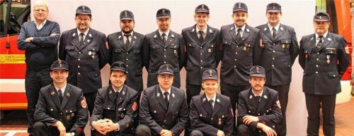 Die Geehrten und ihre Gratulanten: (hintere Reihe, von links) Sebastian Eder, Josef Wick, Markus Drexler, Florian Käsweber, Franz Schmid, Josef Wick junior, stellvertretender Kommandant Erich Weiss und Kommandant Alois Obermüller sowie (vordere Reihe, von links) Zweiter Vorstand Georg Hofstetter, Markus Jakob, Jens Rösler, Carina Willberg und Patrick Skrobek. Foto re