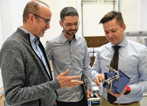 Die drei Tüftler von der Atoma Multipond: (von links) Wolfram Zeck, Konstrukteur Felix Profe, Andreas Peters. Peters, der die Gesamtleitung Entwicklung innehat, hält einen Kunststoffbehälter mit Gitterklappen aus einem Wägesystem in den Händen. Die Gitterklappen verhindern das Anhaften von klebrigen Produkten, wie etwa Käse.Foto vk