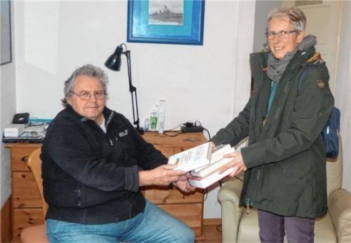 Medienbotin Beate Michael bei der Auslieferung von Büchern an ihren Kunden Detlev Schönhaber.Foto Stadtbibliothek