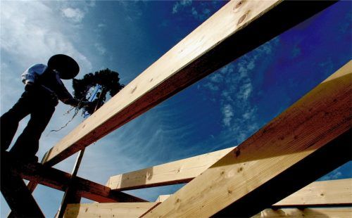 Zimmerer auf einem Dachstuhl: Die Branche wünscht sich mehr Anerkennung für den Baustoff Holz. Foto dpa