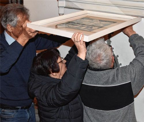 Feinarbeit: Pfarrer Andreas Maria Zach (links) und Dr. Evelyn Frick hängen die Gemälde auf, gemeinsam mit Hilfsmesner Franz Breiter.Foto schlecker