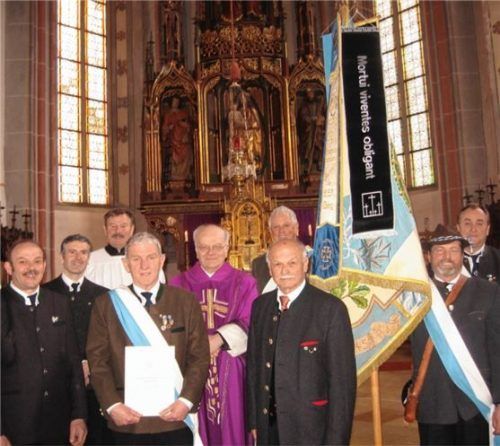 Freut sich über das Fahnenband „Mortui viventes obligant“ an der Fahne: die KSK Obing. Unser Bild zeigt Zweiten Vorsitzenden Andreas Dieplinger, Schriftführer Michael Zierer, Mesner Alois Hofstetter, Ersten Vorsitzenden Ernst Hofstetter, Pfarrer Christoph Kronast, Fahnenbegleiter Max Winkler, dem Bezirksvorsitzenden des Volksbundes Deutsche Kriegsgräberfürsorge von Oberbayern, Heinrich Rehberg, Fähnrich Jakob Stadler sowie Fahnenbegleiter Georg Zehetmaier (von links).Foto rehberg