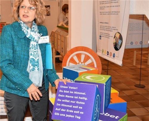 Kuratorin Regina Georg mit dem Gebets-Puzzle in leicht verständlicher Sprache.