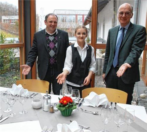 Pfarrer Franz Eisenmann (links) und Dr. Markus Gruber vom Sozialministerium haben sich von der Auszubildenden Luisa Keil zeigen lassen, wie man einen Tisch richtig eindeckt.Foto  re
