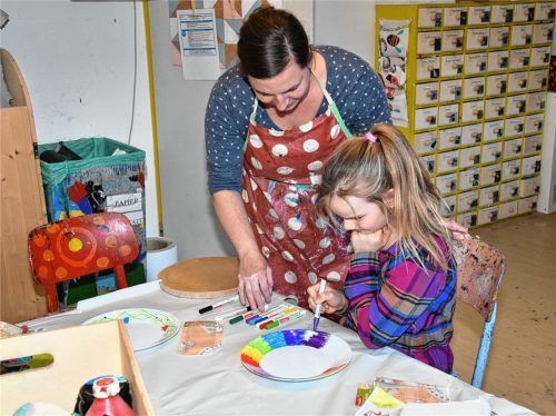 Vroni Heller von „Kind und Werk“ gibt Judith (8) Tipps, wie sie ihren Teller farbenfroh verzieren kann. Foto Schlecker