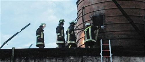 Mitglieder der Feuerwehr Höchstätt löschen am Samstag rauchende Brandreste ab. Foto Reisner