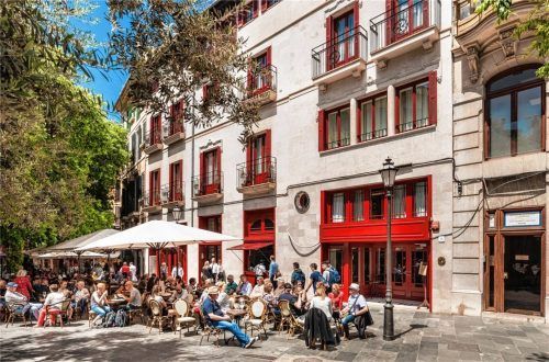 Auf zahlreichen kleinen Plätzen der mallorquinischen Hauptstadt, wie hier der Plaça de Cort, lassen sich Besucher neben Einheimischen nieder. Foto Hotel Cort/Francisco Garvi
