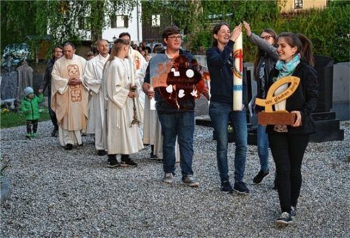 Das Organisationsteam an der Spitze des Kirchenzuges mit der Erinnerungstafel, der Osterkerze und dem Glaubensmotto.