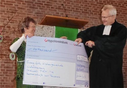 Elsbeth Grytzyk vom Team des Eine-Welt-Ladens überreichte den symbolischen Spendenscheck an Pfarrer Lars Schmidt. Foto  re