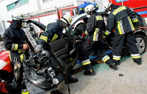 Feuerwehrmänner zerschneiden bei einer Übung auf einem ADAC-Technikzentrum mit einer hydraulischen Rettungsschere die Karosserie eines „Unfallautos“. Bei E-Autos dürfen dabei die Stromleitungen nicht durchschnitten werden. Die wachsende Vielfalt auf den Straßen stellt die Feuerwehren vor immer neue Herausforderungen. Foto dpa