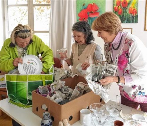 Für den Geschirrmarkt „Aufdeckt is!“ packen die ehrenamtlichen Helferinnen der Caritas-Seniorenbegegnungsstätte Rosenheim, Erika Kirchner, Helga Hadamek und Dorothea Ebert-Lapp, Geschirr aus.Foto re