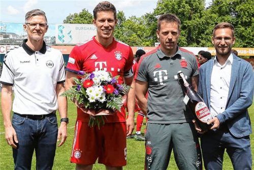 Gratulation: Burghausens Teammanager Karl-Heinz Fenk (links) und Geschäftsführer Andreas Huber (rechts) beglückwünschen Kapitän Nico Feldhahn und Trainer Holger Seitz vom FC Bayern München II zur Meisterschaft in der Regionalliga Bayern.Foto Zucker