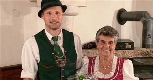 Peter Sattlberger, Vorsitzender des Grainbacher Trach-tenvereins, gratuliert Katharina Estermann zum 80. Geburtstag.Foto Hötzelsperger