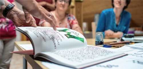 Schreiben, Designen, Komponieren – wer mit einer kulturellen beziehungsweise künstlerischen Tätigkeit hauptberuflich sein Geld verdient, bereichert die regionale Kultur- und Kreativbranche. Im Bild zeigt eine Dozentin den Teilnehmern ihres Kalligrafiekurses ein selbst gestaltetes Kochbuch. Foto dpa