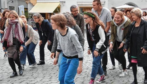 Seite an Seite: 40 Menschen nahmen in Rosenheim an der Unicef-Aktion „Theater der 10000“ teil. Über Kopfhörer gab es Regieanweisungen. Hier schleichen die Teilnehmer in Zeitlupe über den Max-Josefs-Platz.Foto Schlecker