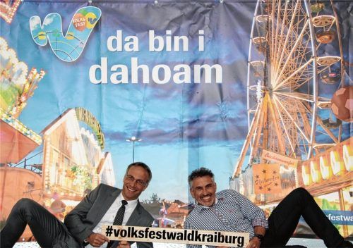 Volksfestpräsentation einmal anders: Bürgermeister Robert Pötzsch (links) und Volksfest-Organisator Norbert Meindl vor einem Volksfesttransparent, das im Rathaus aufgebaut ist. Ab sofort können dort Volksfestfreunde, Gruppen, Familien, Fotos von sich machen und damit an einem Wettbewerb teilnehmen. Als Preise locken drei Brauereiführungen im Hofbrauhaus Freising.Foto  Stadt