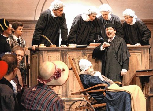 Auch vor Gericht stellt sich Herr von Fuchs (Andreas Bauer) todkrank, während die vier Richter (Toni Obermair, Dieter Hoffmann, Thomas Stocker, Georg Feicht) versuchen, den verschlungenen Ausführungen des Advokaten (Bernhard Obermair) zu folgen. Foto Volkstheater Flintsbach