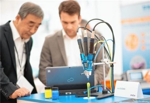 Ein Beispiel für Dosiertechnik, wie sie auf dem Innovationstag von ViscoTec gezeigt wurde: Ein Mikro-Dosierspender dosiert gleichzeitig zwei verschiedene Farben auf ein Glas. Foto re