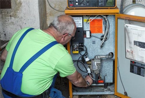Ein Heizungsmonteur kontrolliert eine ältere Heizungsanlage in einem Privathaushalt. Solche Anlagen werden die Azubis der Branche nicht mehr lange zu sehen bekommen. Die SHK-Betriebe sind auf erneuerbare Energien eingestellt. Fotos dpa, re