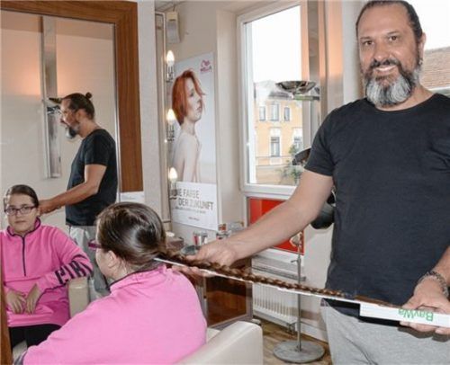 Friseur Tom Fuchs nimmt bei Lea Rados Maß.