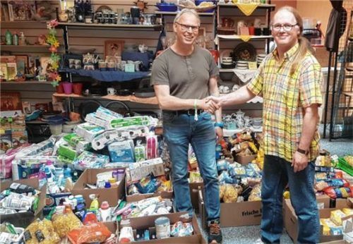 Michael Wagner, Pfarrverband Waldkraiburg (links), und Hilmar Michael Pavlicek, Mitarbeiter des Rotkreuz-Shop Waldkraiburg, inmitten von Spenden, die die Firmlinge gesammelt hatten.Foto  re
