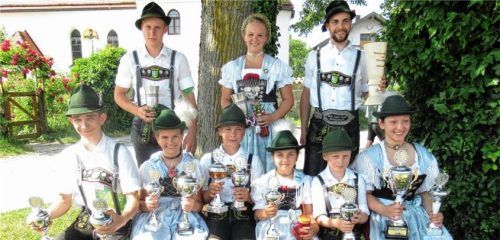 Mit Stolz präsentieren die Dirndl und Buam ihre Pokale (von links oben): Peter Steindlmüller, Stephanie Schmaus und Sepp Stuffer sowie (von links unten) Dominik Riebow, Maja Stangl, Anian Unterseher, Eva Schmid, Matthias Hallmann und Nani Eschenbach. Foto re