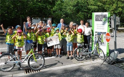 Tanja Maierhofer, Polizei Waldkraiburg (hinten von rechts), Verkehrserzieher Harald Jungbauer, Helga Bauer-Hanauer, Vorsitzende Kreisverkehrswacht, Markus Putz, Vorstandsvorsitzender der Sparkasse, Landrat Georg Huber, Lehrerin Christine Lenk und Daniel Mildner (Sparkasse) mit den Schulkindern aus Kraiburg auf dem Übungsgelände.Foto  Bachmaier
