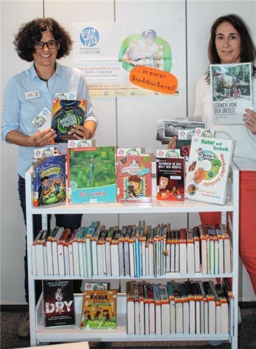 Tatjana Feuerer (rechts, mit dem Hauptpreis) und Andrea Sondhauß mit einem Teil der neuen Leseclub-Bücher. Foto re