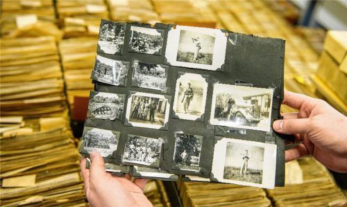 Ein Archivar hält im Archiv des DRK-Suchdienstes in München eine Karteikarte mit mehreren Fotos in den Händen. Nach dem Zweiten Weltkrieg war der Suchdienst des Deutschen Roten Kreuzes ein Rettungsanker, um Familienangehörige wiederzufinden. Foto dpa