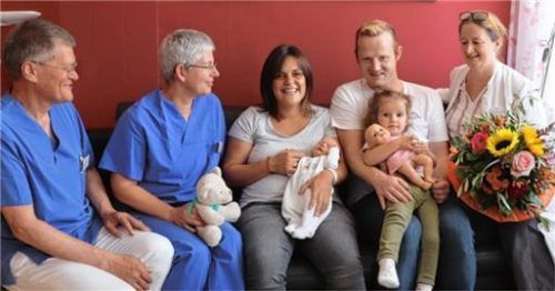 Freude über das Jubiläumsbaby: Leitende Oberärztin Anja Britta Stopik (rechts), Dr. Wilfried Baldauf-Sobez und die Hebamme Lisa Rehmann-Zauner überreichten den Eltern Maria und Christian Freiberger sowie deren Tochter Verena einen Blumenstrauß und einen Teddybären zur Geburt von Elias. Foto Romed-Klinikum