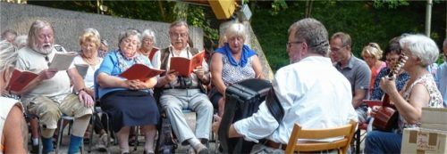 Gemeinsam gesungen: Eva Bruckner (Gitarre) und Ernst Schusser (Ziehharmonika) vom Volksmusikarchiv Oberbayern lockten viele Waldkraiburger Sängerinnen und Sänger in den Stadtpark, unter ihnen auch Bürgermeister Robert Pötzsch (im Hintergrund) und Klaus Ertelt (Bildmitte), der das Volkslieder-Selber-Singen in Waldkraiburg etabliert hatte. Foto  Fischer