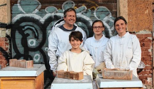 Imker mit ganzem Herzen: Familie Neumann aus Waldkraiburg mit ihren Bienenstöcken auf dem Stadtbau-Grundstück. Michael Neumann (von links), Sohn Manuel, Tochter Svenja und Mama Annette sind von diesem Hobby begeistert.