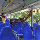 Baggerschaufel gräbt sich in Schulbus
