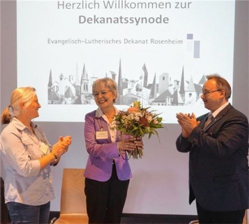 Blumen und Applaus zum Abschied: Gudrun Probul (links) und Synodenpräsident Martin Busch danken Dekanin Hanna Wirth. Foto Dekanat Rosenheim