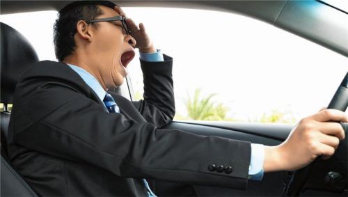 Gähnen, schwere Lider, Gedanken, die abdriften: Wer hinter dem Lenkrad müde wird, sollte dringend eine Pause einlegen. Foto Tom Wang/Shutterstock