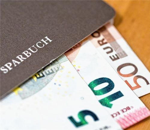 Geldscheine liegen in einem Sparbuch: Sparbeträge auf dem Bankkonto können je nach Höhe der Summe mit einem Negativzins belastet werden. Bayerns Ministerpräsident Söder und Bundesfinanzminister Scholz wollen das für Kleinsparer gesetzlich verbieten lassen. Die Banken müssten ihre Kosten anders ausgleichen. Foto dpa